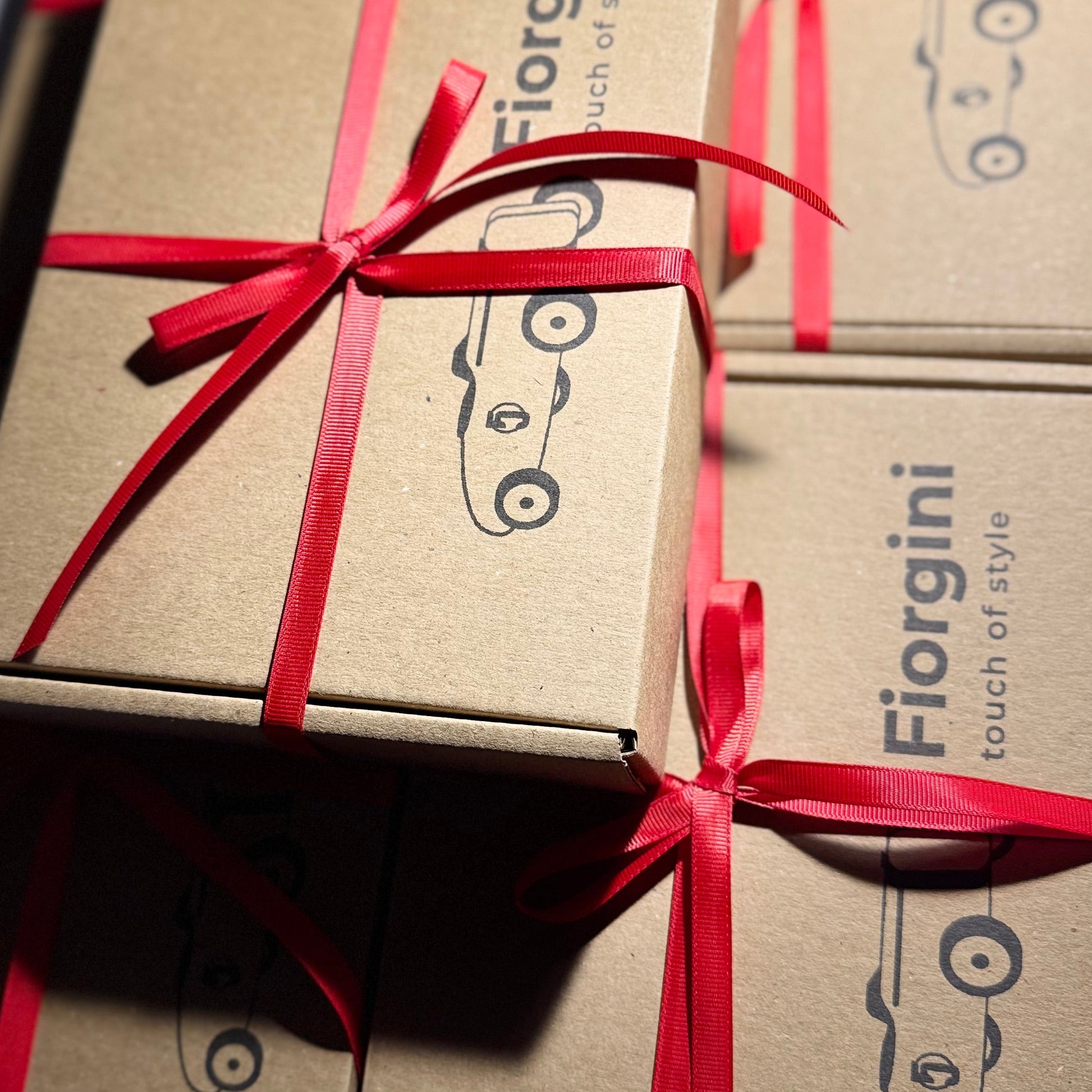 Brown boxes with red ribbons and 'Fiorgini' branding on a white background