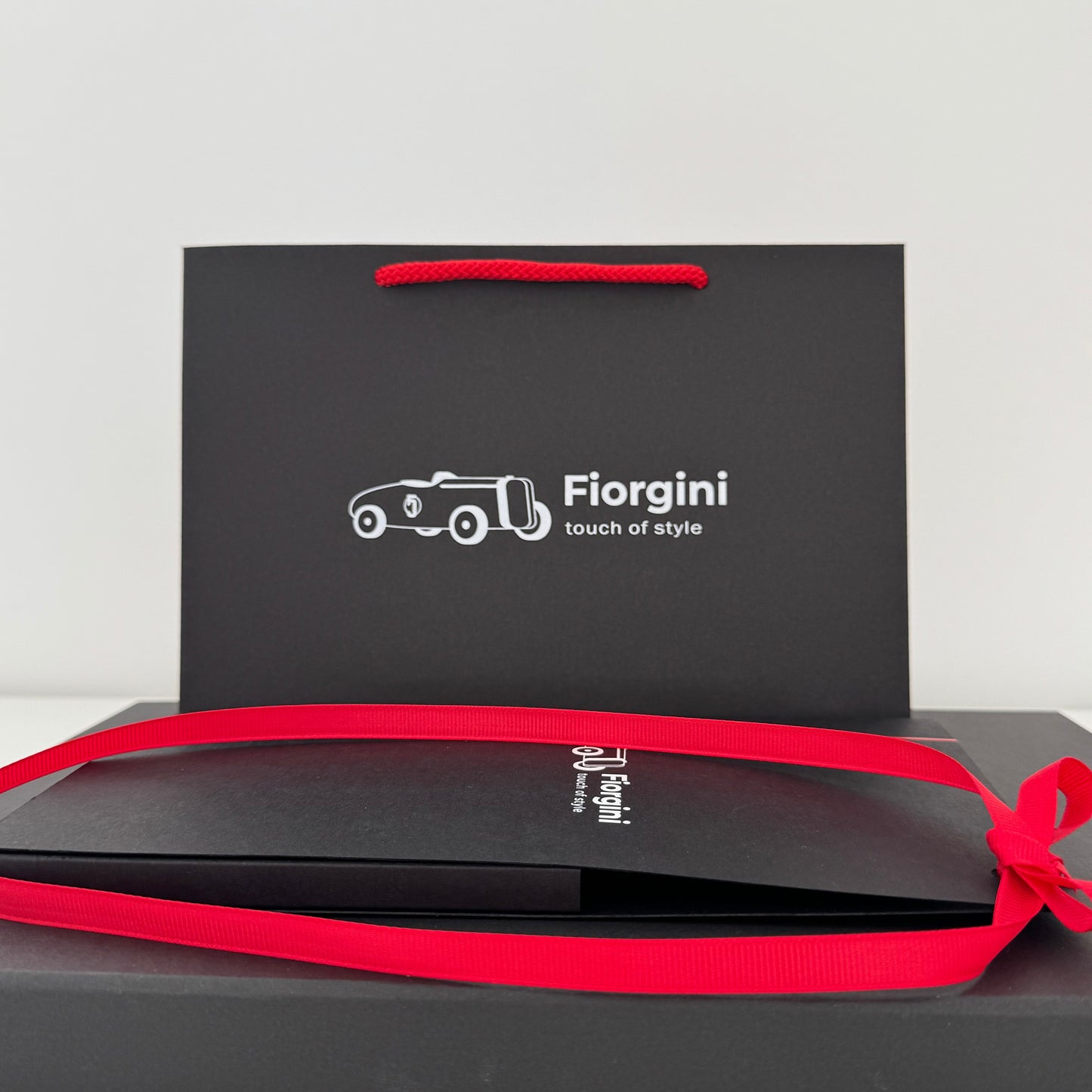 Black gift box with red ribbon and 'Florgini' branding on a white background