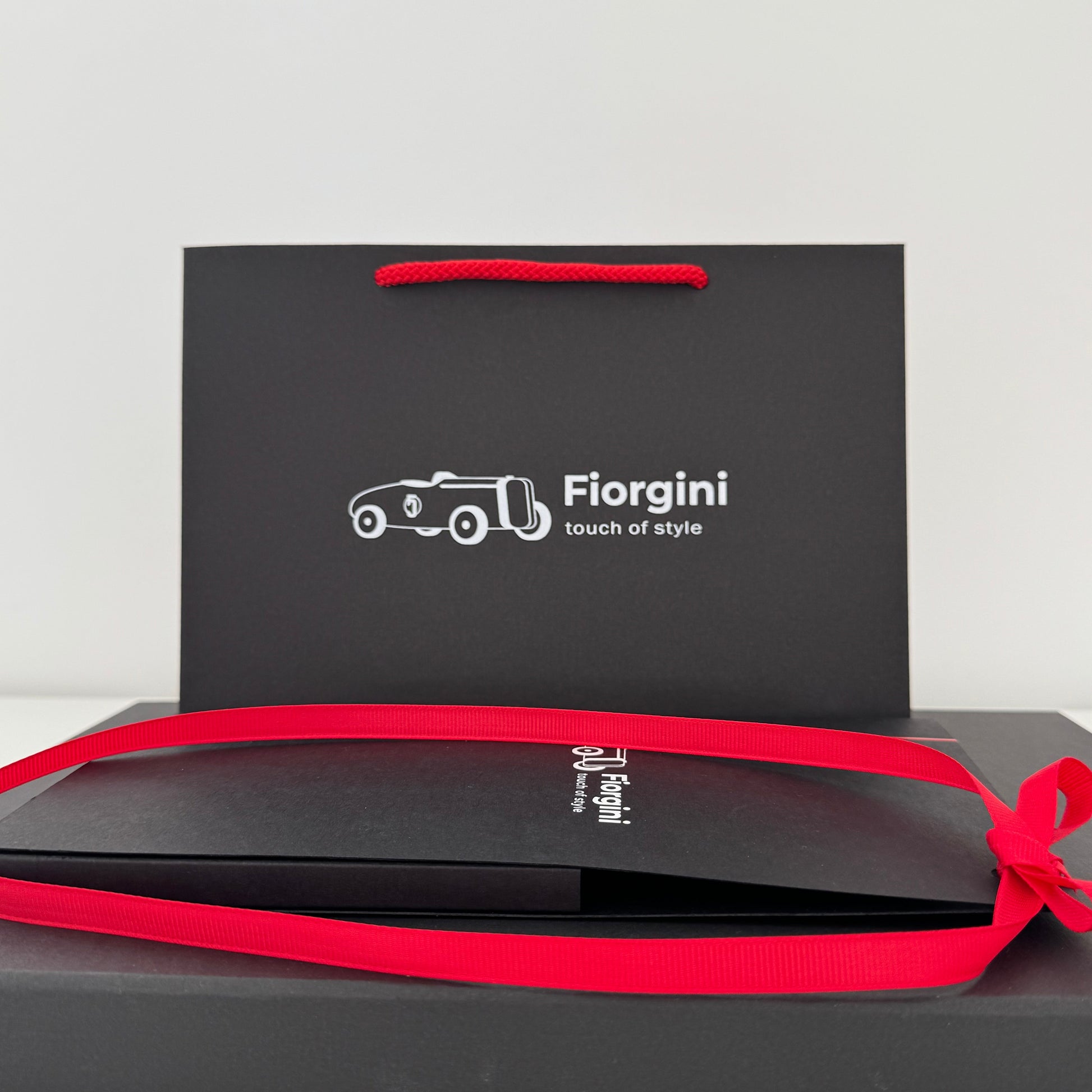 Black gift box with red ribbon and 'Florgini' branding on a white background